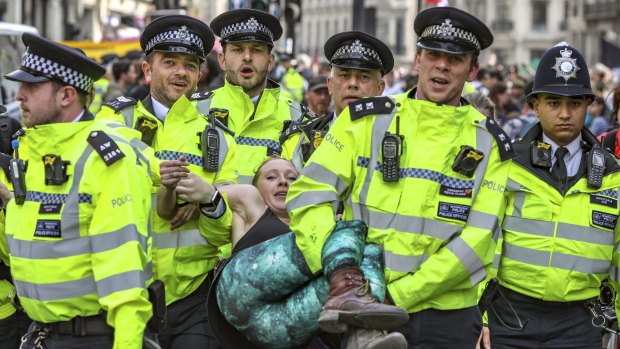 Police arrest protesters as they block traffic on London's Oxford Circus.