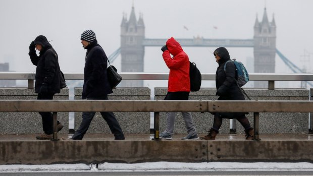 Hard to imagine a water shortage: Commuters make their way across London Bridge facing inclement weather in London, UK.