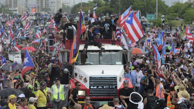 Puerto Rican singer Ricky Martin, front atop truck, participates with other local celebrities in a protest demanding the resignation of governor Ricardo Rossello in San Juan on Monday.