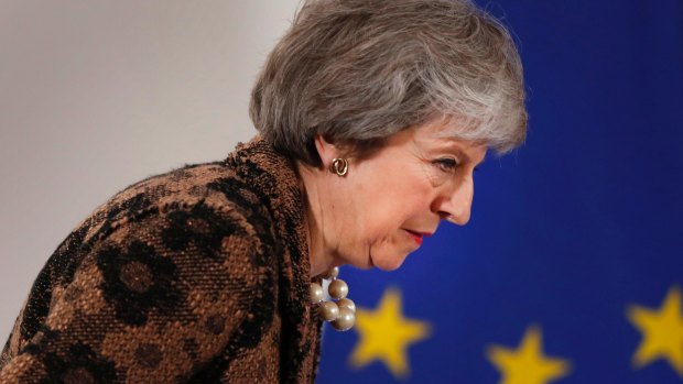 British Prime Minister Theresa May walks by the EU stars as she arrives for a media conference at an EU summit in Brussels, on Friday.