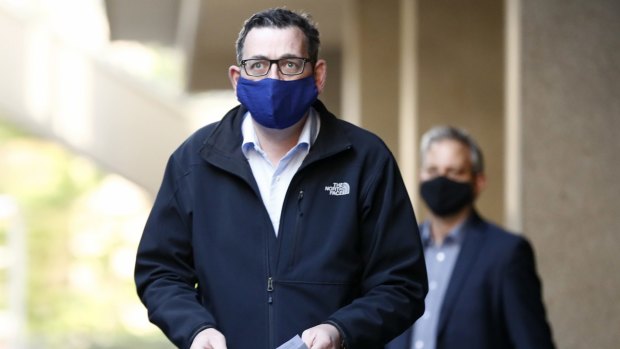Victorian Premier Daniel Andrews wears a face mask as he walks into the daily government briefing on Sunday.