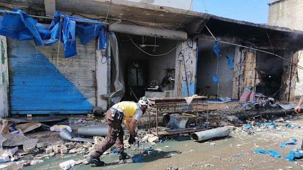 A White Helmet civil defence member works outside damaged shops after shelling hit a street in the town of Ehssem, southern Idlib, on Friday. 