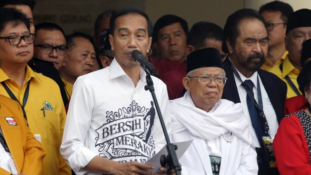 Indonesian President Joko "Jokowi" Widodo, centre left, speaks as his running mate Ma'ruf Amin, centre right, listens prior to formal registration as candidates for the 2019 presidential election in Jakarta, Indonesia.