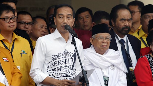 Indonesian President Joko "Jokowi" Widodo, centre left, speaks as his running mate Ma'ruf Amin, centre right, listens prior to formal registration as candidates for the 2019 presidential election in Jakarta, Indonesia.