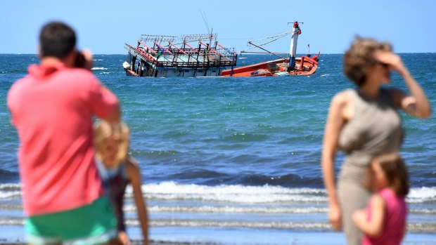 A sunken fishing vessel, believed to be carrying Vietnamese asylum seekers, is seen off the beach at Cape Kimberley at the mouth of the Daintree River.