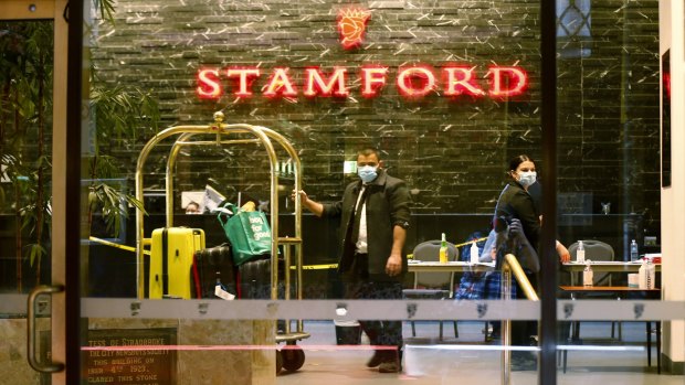 Masked workers inside the Stamford hotel during the quarantine program.