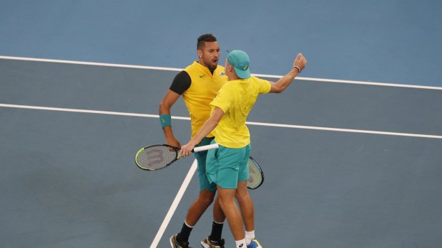Australia's Alex De Minaur and Nick Kyrgios celebrate after winning the decisive doubles rubber against Great Britain.
