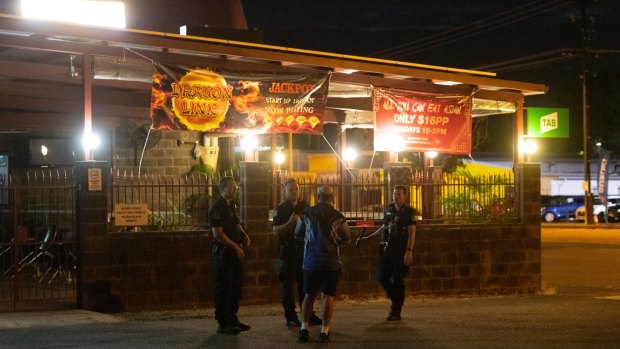 Police speak with an employee at the Buff Club, where a male was shot and killed in the car park.