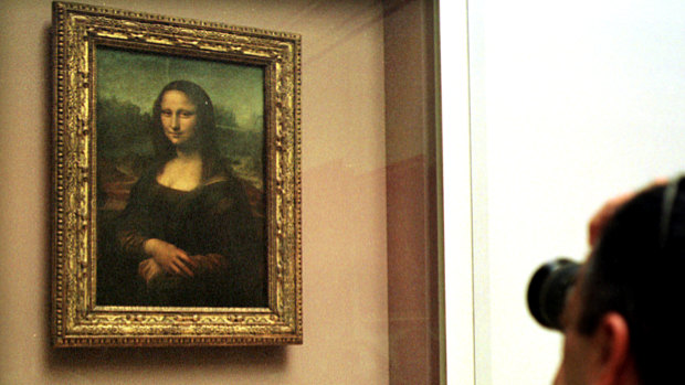 The Mona Lisa behind protective glass in the Louvre. 
