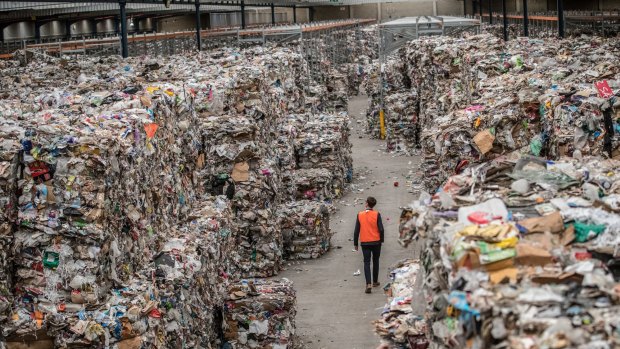 A warehouse stacked to the rafters with bales of waste intended for recycling.