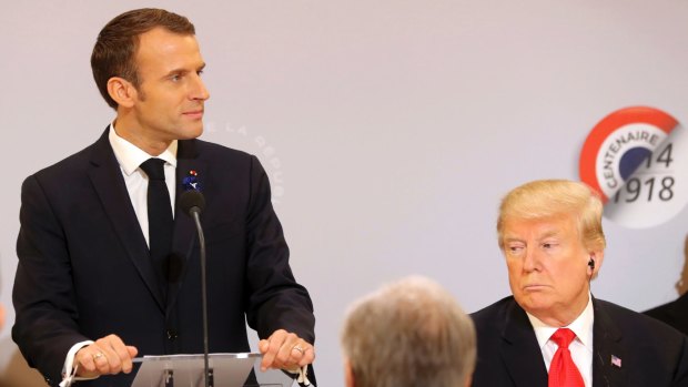 Emmanuel Macron delivers a speech while Donald Trump looks on at the Elysee Palace, in Paris, on November 11.