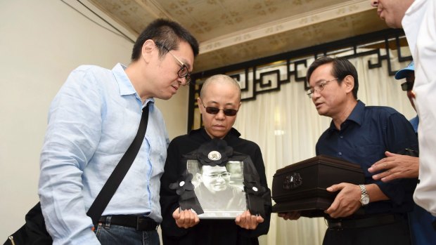 Liu Xia, centre, holds her husband's portrait during his funeral in Shenyang in July 2017.