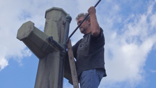 A photo of a Catholic Worker movement member removing the sword from the Cross of Sacrifice on Ash Wednesday in 2017.