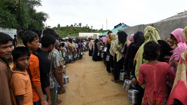 Rohingya refugees queue for a meal provided by an aid agency in Bangladesh.
