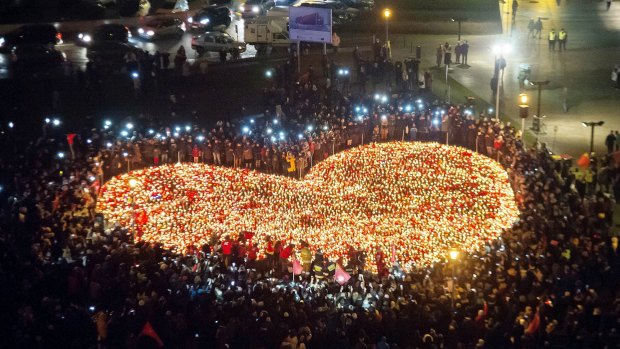 People stand by a heart shaped with candles as a tribute to  Pawel Adamowicz , the mayor of  Gdansk, murdered last week.