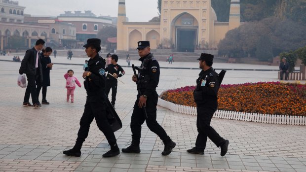 Security personnel on patrol outside a mosque attended by Uighurs in Xinjiang.