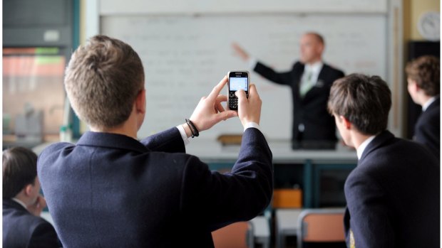 A new review of the evidence on the impact of phones in classrooms has found that schools have taken opposing stances.