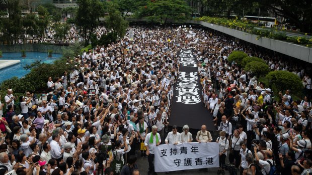 Demonstrators carry  banners during a protest organised by the elderly in the central district of Hong Kong on July 17.