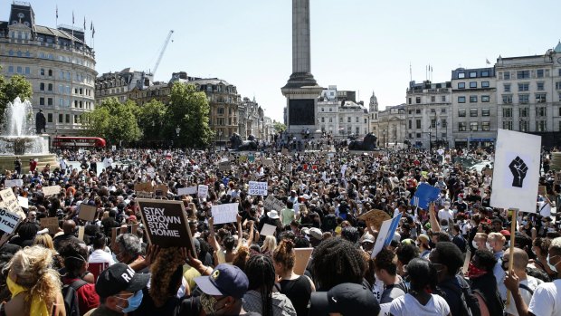 People hold placards as they join a Black Lives Matter march at Trafalgar Square in London in 2020.