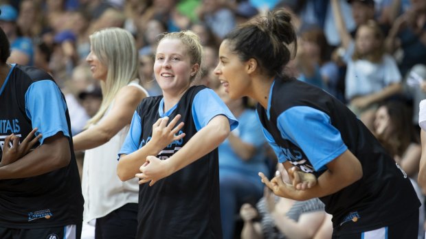 The Canberra Capitals bench react to a Leilani Mitchell triple - pretending to nurse a baby.