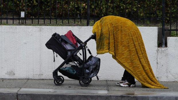 A homeless person shields themselves from the rain in Los Angeles. 