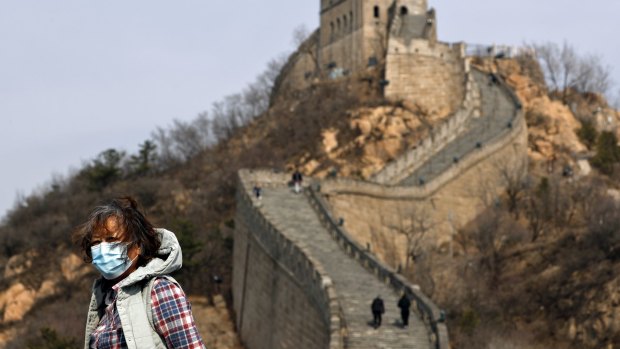 A woman wearing a protective face mask visits the Badaling Great Wall of China after it reopened for business.