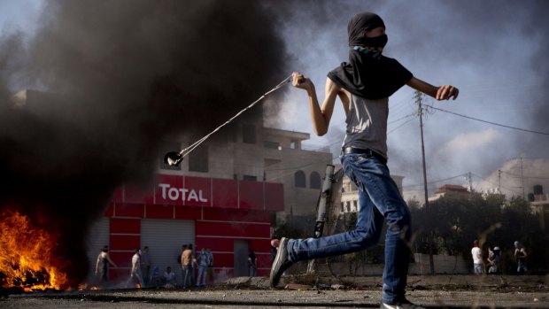 A young Palestinian hurls a stone during clashes with Israeli troops near Ramallah. 
