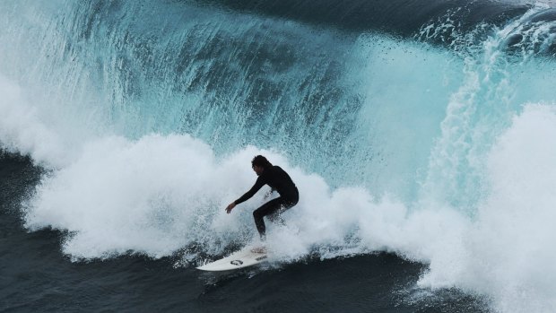 Surfers use the growing swell along the Sydney coast. This afternoon it will grow to near 15 feet