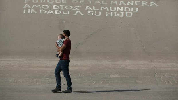 A migrant man and child cross the border illegally into the US to turn themselves into authorities and ask for asylum near El Paso, Texas.