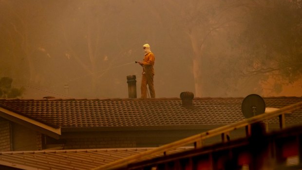 Residents in Bawley Point hose their roofs as a bushfire threatened.