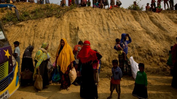 Rohingya Muslims watch from atop a hill as new refugees arrive in Balukhali refugee camp, Bangladesh.