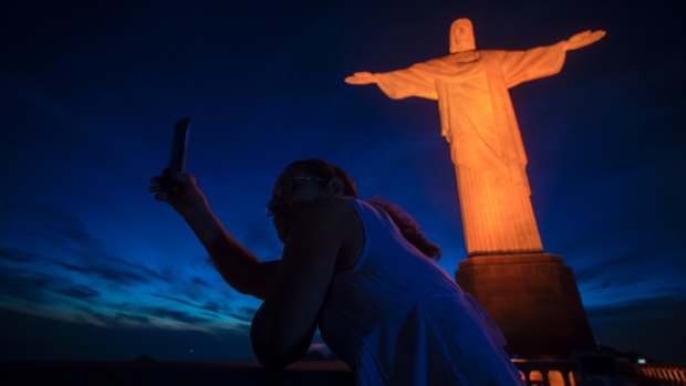 A tourist takes a selfie with the Christ the Redeemer. The tourist attraction has been closed due to coronavirus.