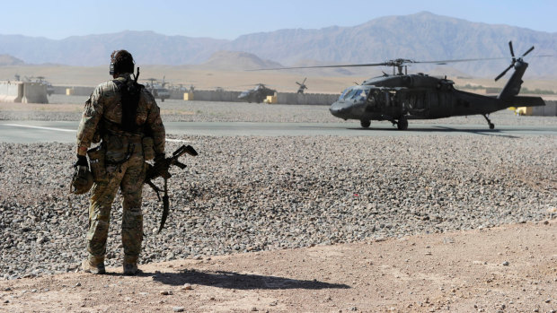 An SAS soldier awaits the arrival of a UH-60 Blackhawk helicopter in Afghanistan.