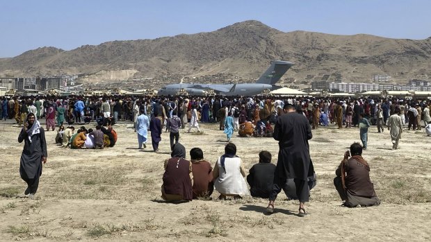 Hundreds of people gather near a US Air Force transport plane at the international airport in Kabul, Afghanistan on Monday.