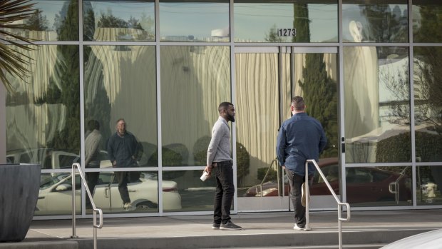 People stand outside an Apple satellite office building in Sunnyvale, California.