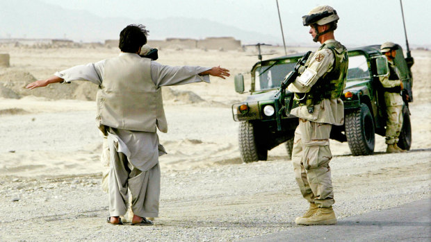 US soldiers frisk an Afghan man at a roadside checkpoint near Kandahar, Afghanistan, in 2004. In 2012 American forces were using electronic scanning at some checkpoints.