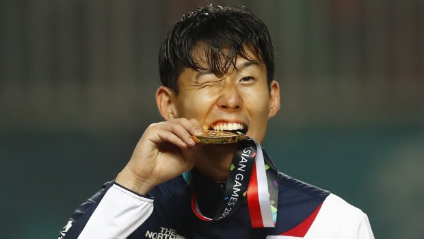 Exemption: South Korea's Son Heung-min celebrates on the podium after winning the Asian Games gold medal.