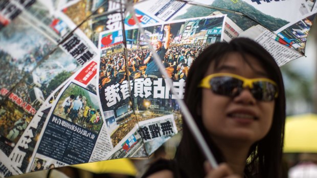 A pro-democracy activist shelters from the sun under an umbrella designed with images from the Occupy Central protests as she attends a pro-democracy rally against a controversial political reform package in the Tsim Sha Tsui district of Hong Kong in 2015. 