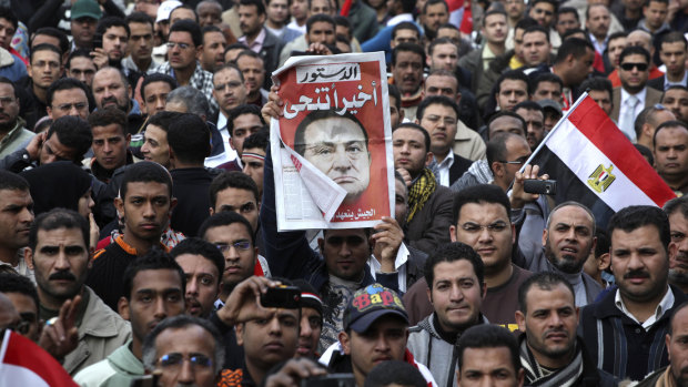 February, 12, 2011:  A protester holds up a sign that reads 'Finally he steps down' in Tahrir Square, Cairo.