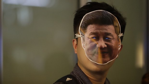 A protester wearing a mask depicting Chinese President Xi Jinping attends a protest in Hong Kong.