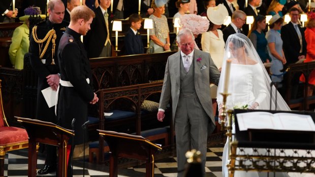 Britain's Prince Harry looks at Meghan Markle as she arrives accompanied by the Prince Charles during the wedding ceremony.