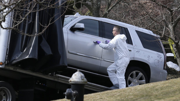 Crime scene investigators load a car that appears to have been checked for fingerprints onto a truck outside Francesco Cali's home.