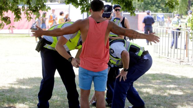 Police with sniffer dogs search people for drugs entering the Summadayze festival in Sydney.
