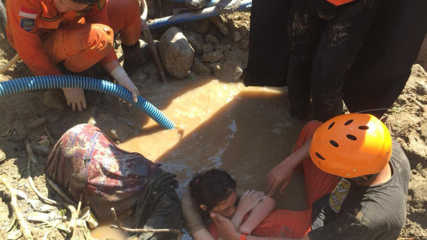 An Indonesian rescue team evacuates a women from damage following earthquakes and a tsunami in Palu, Central Sulawesi, Indonesia, on Sunday.