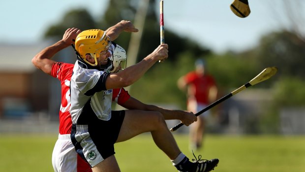 Sydney Shamrocks hurler and captain Niall Holmes (left) mid air as his hurley is snapped in half during a match against Central Coast at Ingleburn in May 2015. 