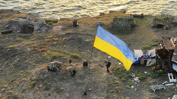 Ukrainian soldiers install the state flag on Snake Island in the Black Sea.