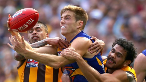 Brad Sheppard of the Eagles handballs whilst being tackled by Bradley Hill and Cyril Rioli of the Hawks  during the 2015 AFL Grand Final match between the Hawthorn Hawks in 2015.