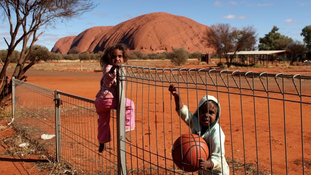 Children play near Uluru.