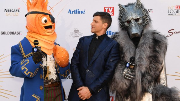 Host Osher Gunsberg (centre) and characters from the The Masked Singer.