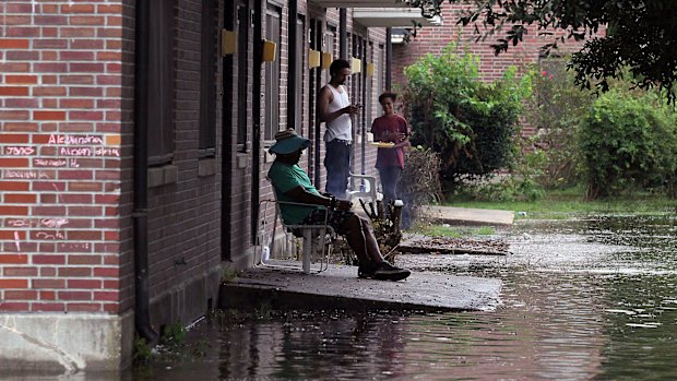 Residents at Trent Court Apartments wait out the weather as rising waters get closer to their doors.